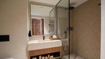 A modern bathroom with a glass shower enclosure, a vanity with a mirror, and a bathtub.