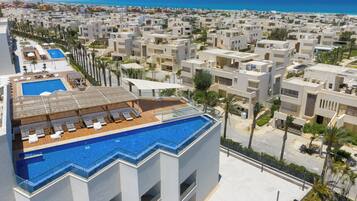 A resort with a rooftop pool and a view of the beach.