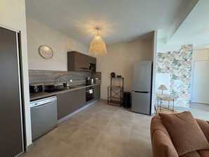 A modern kitchen with a built-in dishwasher, a microwave, and a refrigerator. - Tropical Elegance - 2-Bedroom Apartment with Terrace, Walking Distance to the Beach in L'Ermitage (Saint gilles les bains)
