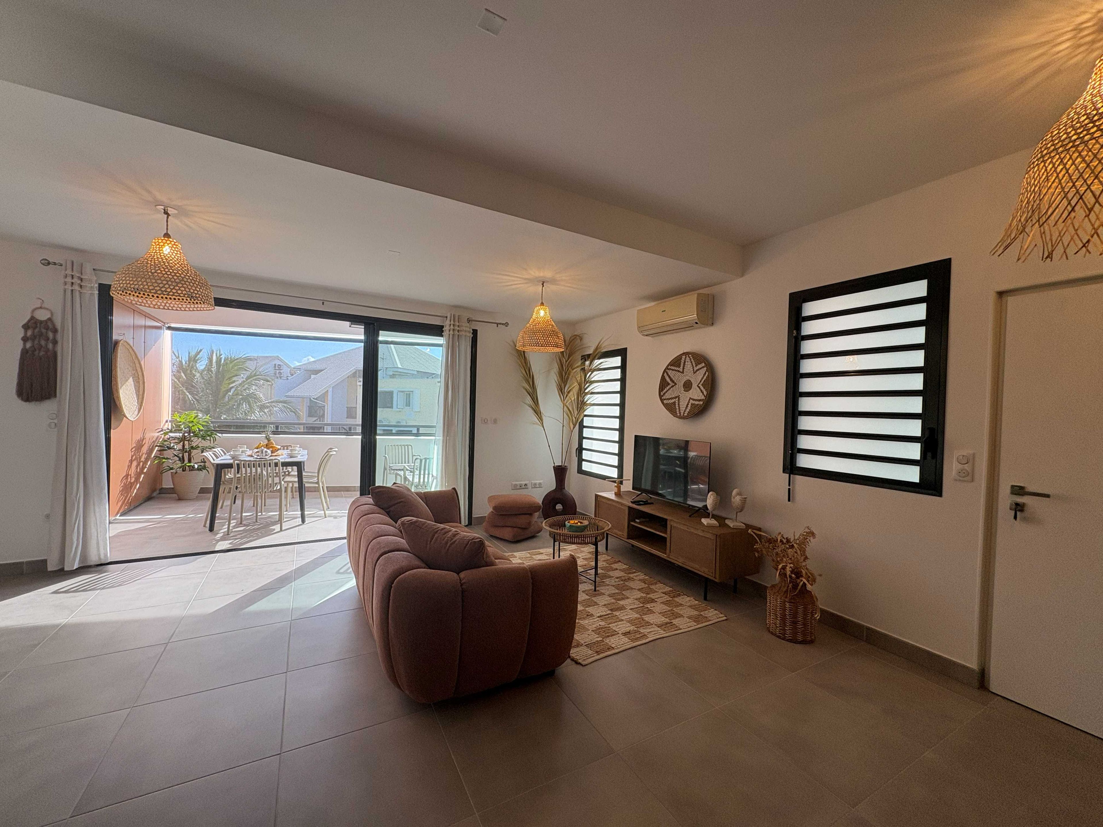 A modern living room with a sofa, TV, and dining area.