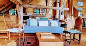 A cozy log cabin interior with a blue sofa, wooden furniture, and a chessboard. - Exceptional Chalet - Panoramic View - Sauna - Aravis (Serraval)