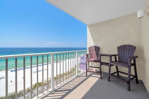Ein Balkon mit Blick auf Strand und Meer.