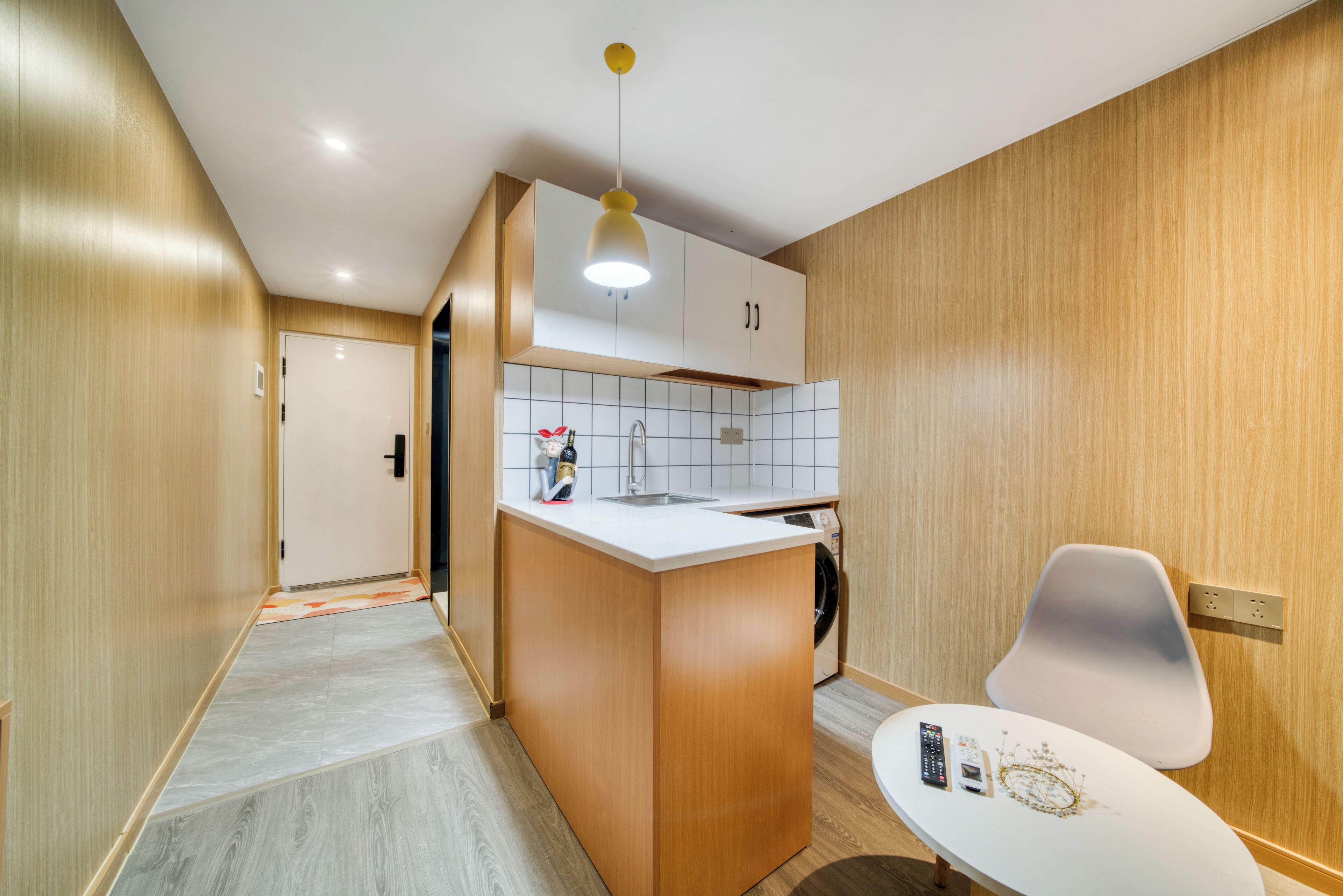 A modern kitchen with wooden cabinets, a white countertop, and a built-in washing machine.