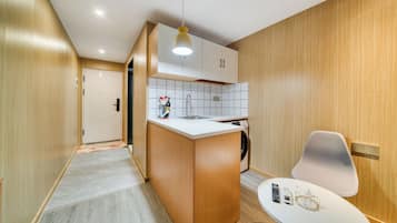 A modern kitchen with wooden cabinets, a white countertop, and a built-in washing machine.