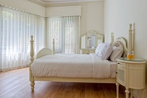 A bedroom with a bed, a nightstand, a mirror, and sheer curtains. - Vesta - Luxury APT - 2BR - Zamalek II (Cairo)
