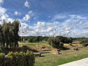 Ein Park mit einer Flagge, Bäumen und Steingebäuden.