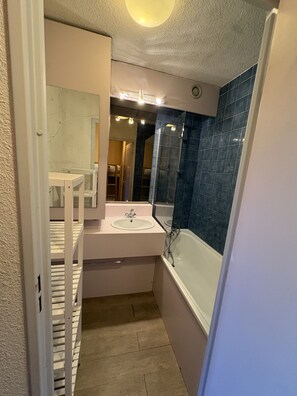 A compact bathroom with a white sink, a glass-enclosed shower, and a mirror above the sink. - Cabin studio with mountain view (Orcières)