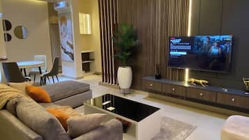 A modern living room with a sofa, coffee table, TV, and decorative elements.