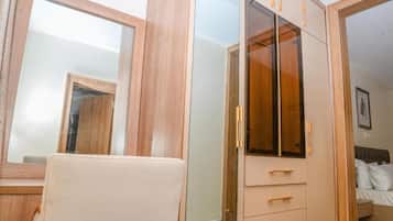 A bedroom with a bed, a wardrobe, and a mirror.