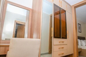 Un dormitorio con una cama, un armario y un espejo.