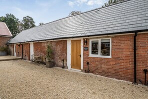 A brick building with a gravel driveway, a wooden door, and a sign that reads 'WILLOW BROOK'. - Willow Brook, Hamptworth, Hampshire (Salisbury)