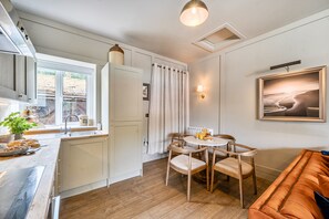 Une cuisine moderne avec une fenêtre, un coin repas comprenant une table et des chaises, et un canapé.