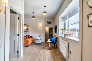 Ein stilvoller Wohnraum mit einer Couch, einem Esstisch und einem Fenster mit Blick.