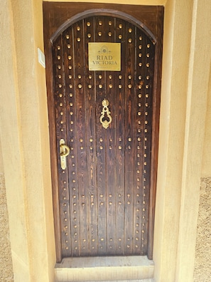 A wooden door with a brass knocker and a sign reading 'RIAD VICTORIA MARRAKECH'. - Riad Victoria (Marrakech)