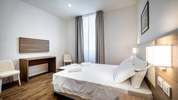 Una habitación de hotel moderna con una cama grande, un escritorio y una silla.
