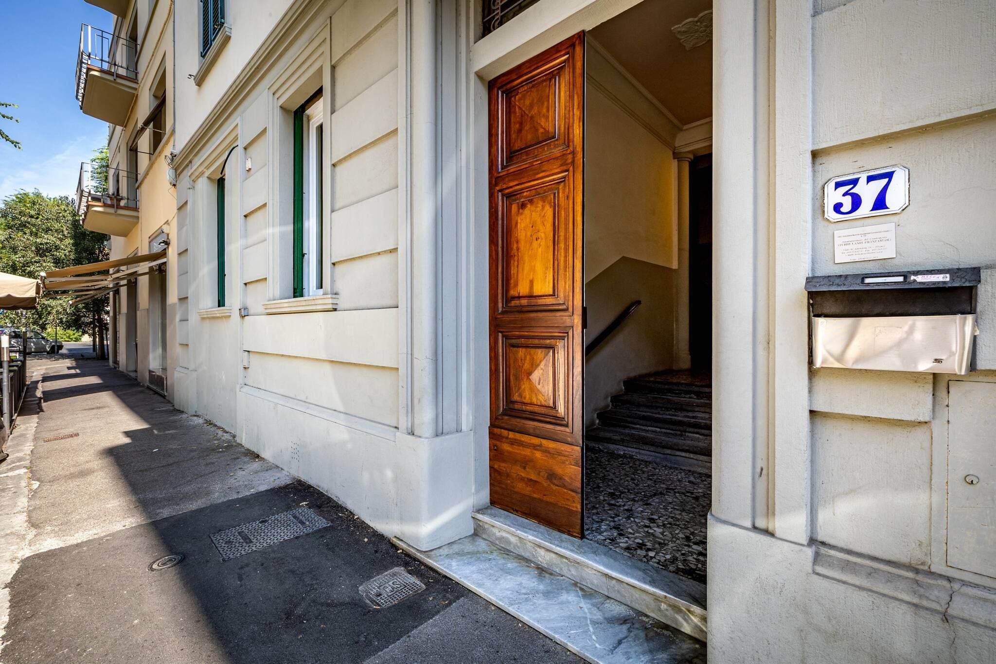 Un edificio con una puerta de madera y un letrero con el número 37.