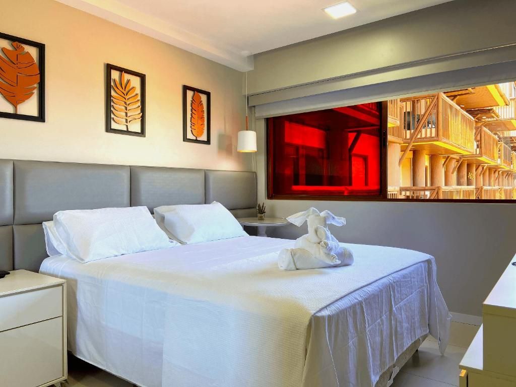 Quarto de hotel com cama, mesa de cabeceira e decoração na parede.