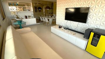 A modern living room with a sofa, a TV, and a yellow appliance.