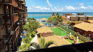 A resort with a pool, outdoor seating, and a view of the ocean. - Cobertura Vista Mar Barra Bali (Barra de São Miguel)