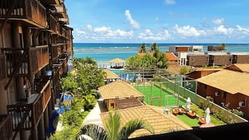 A resort with a pool, outdoor seating, and a view of the ocean.