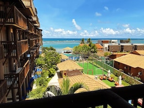 Un resort con piscina, mobiliario exterior y vista al océano.