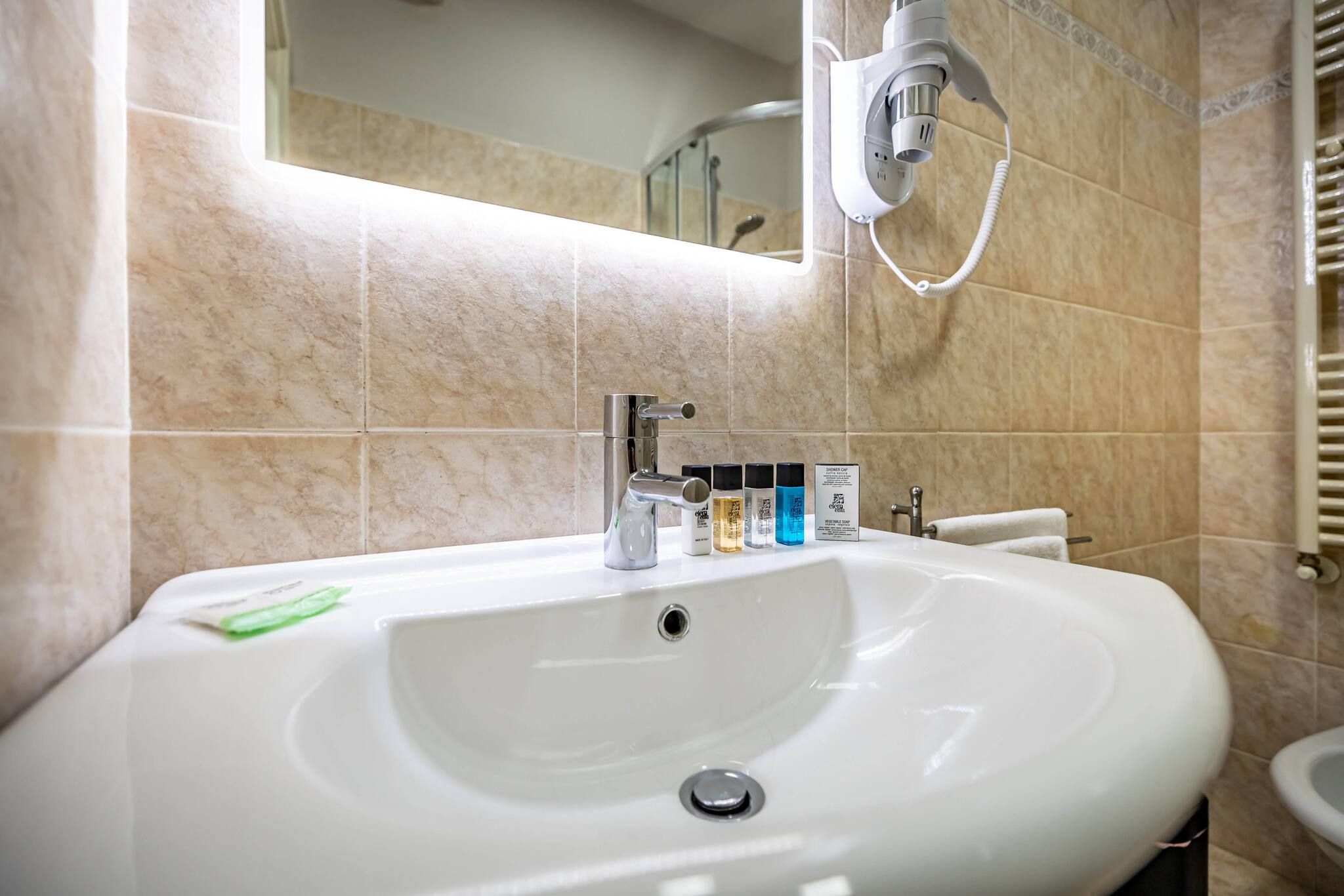 A bathroom with a white sink, a mirror, and a towel rack.