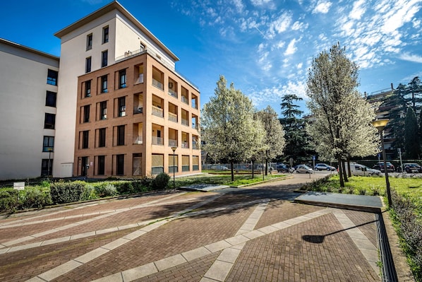 A multi-story residential building with a brick facade, a flat roof, and a balcony on the upper floors. - Castelnuovo Tedesco (Florence)
