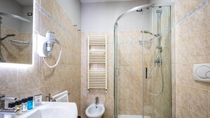 A modern bathroom with a glass-enclosed shower, a pedestal sink, and a bidet. - Castelnuovo Tedesco (Florence)