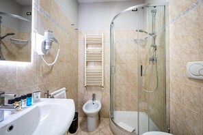 A modern bathroom with a glass-enclosed shower, a pedestal sink, and a bidet. - Castelnuovo Tedesco (Florence)