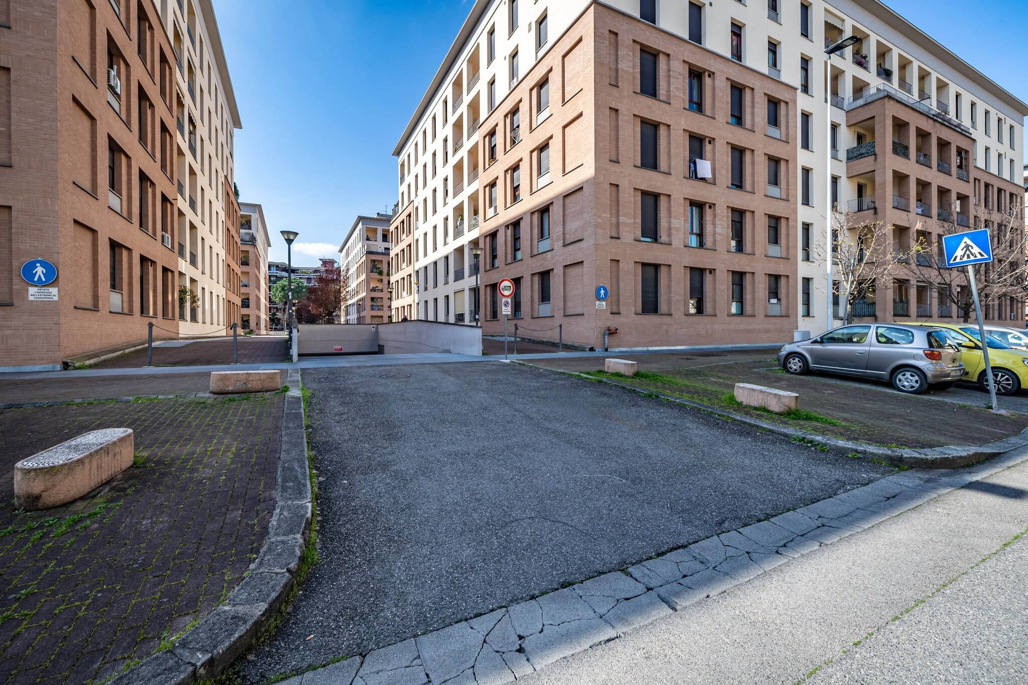 Un immeuble à plusieurs étages, doté d’une façade en briques, d’une cour pavée et d’un chemin piétonnier.