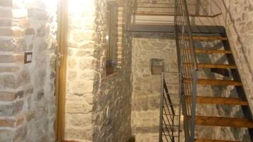 Eine Treppe mit Holzwurf und Metallspindeln, die zu einer Steinmauer führt.