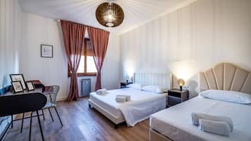A hotel room with two beds, a desk, and a chair.