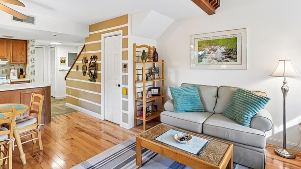 A living room with a sofa, coffee table, and a staircase leading to another room. - First Cub 1301 (Gatlinburg)