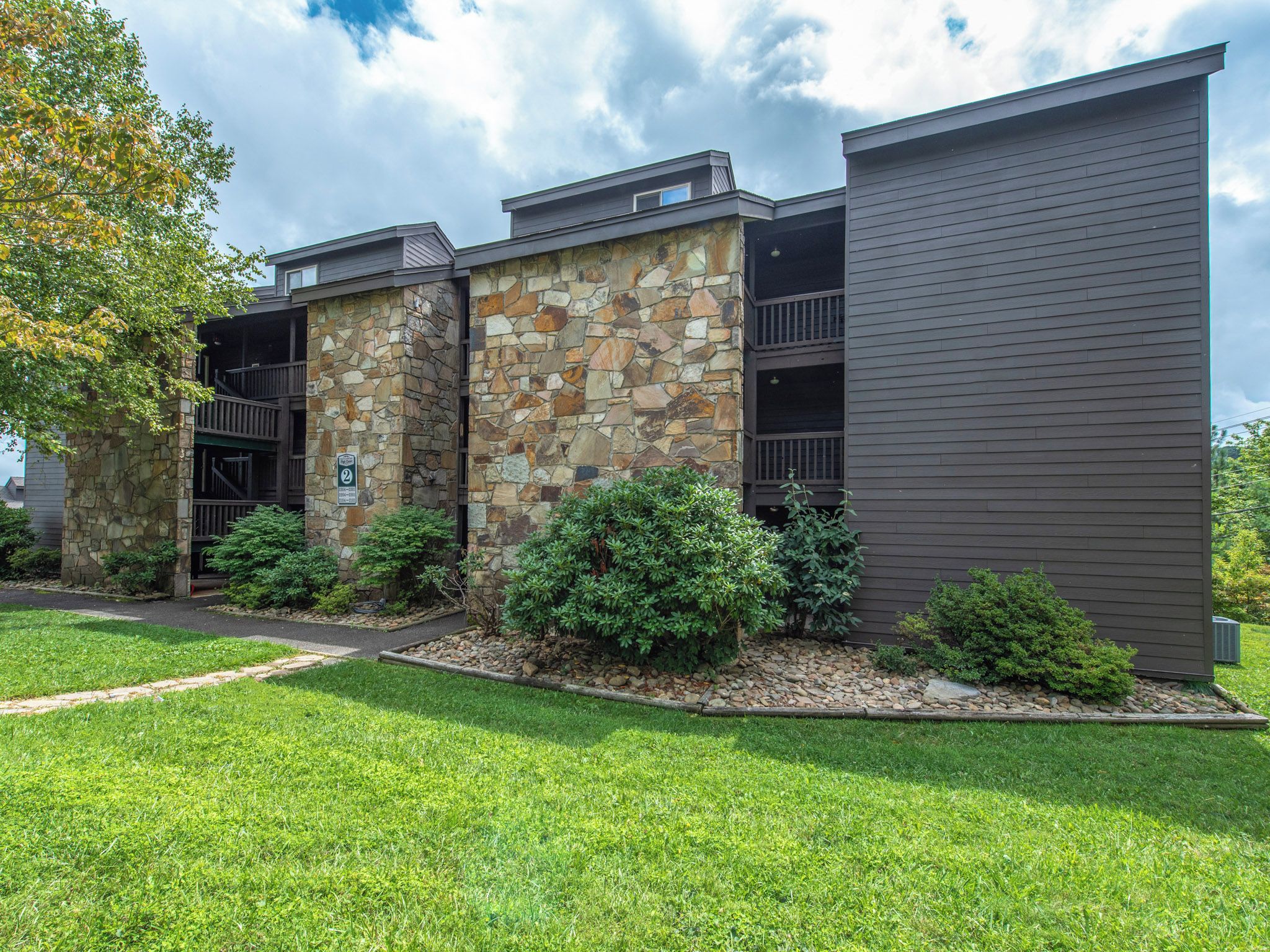 A modern building with a stone facade and a dark wooden exterior.
