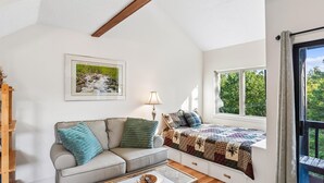 A cozy room with a sofa, a window seat, a framed picture, and a lamp. - First Cub 1301 (Gatlinburg)