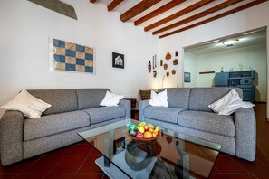 A living room with two grey sofas, a glass coffee table with fruit, and a bulletin board on the wall. - San Frediano (Florence)