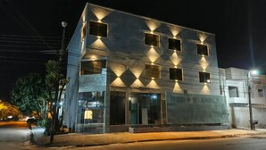 Un edificio moderno con fachada de vidrio, múltiples ventanales y una entrada bien iluminada.