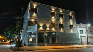 Un edificio moderno con fachada de vidrio, múltiples ventanales y una entrada bien iluminada.