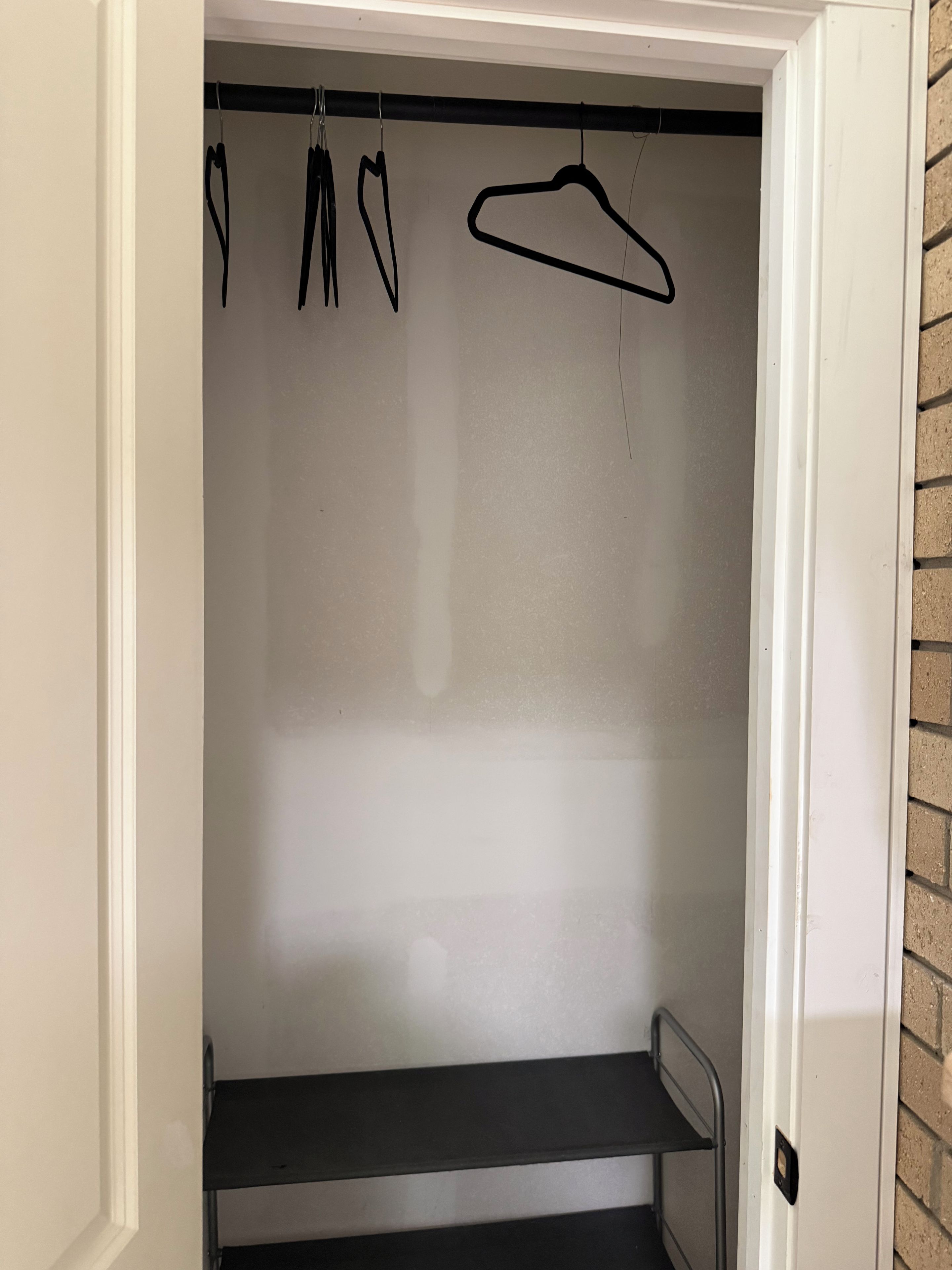 Ein Schrank mit Kleiderstange und Ablagefläche.