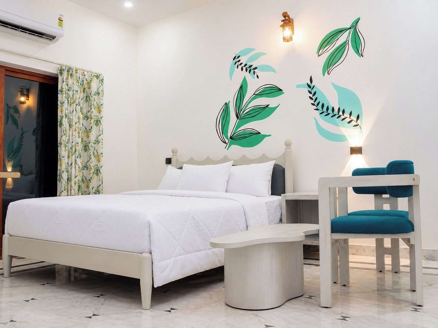 A bedroom with a bed, a bedside table, a chair, and wall art.