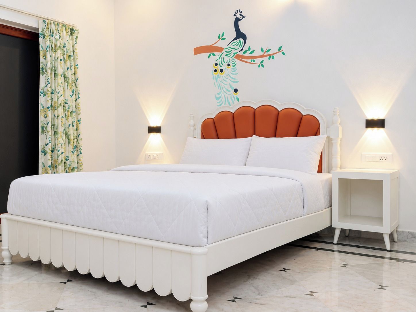 Una cama con estructura de madera con forma de concha, ropa de cama blanca y dos lámparas de noche.