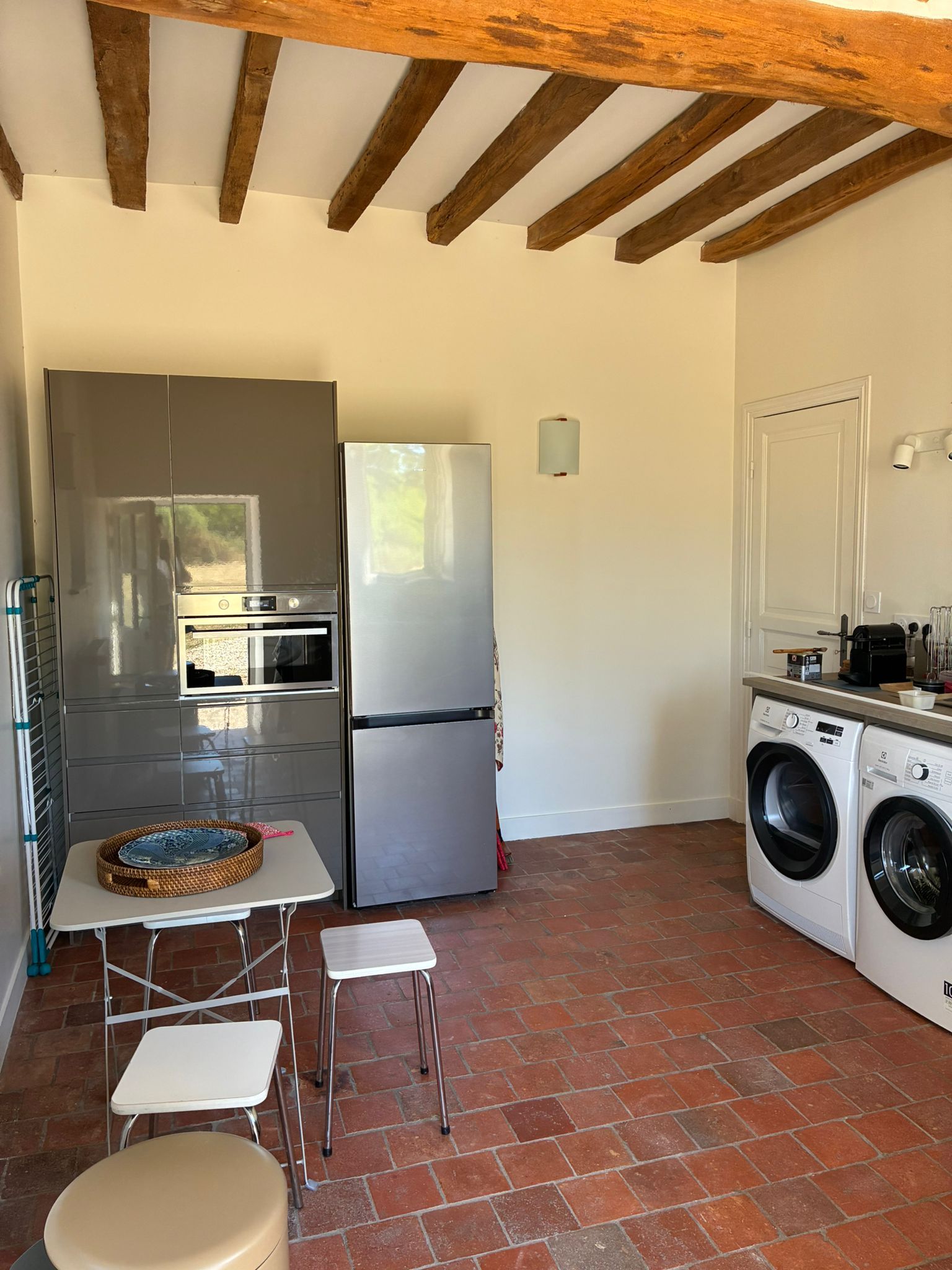 A compact kitchen with a refrigerator, oven, and washing machine.