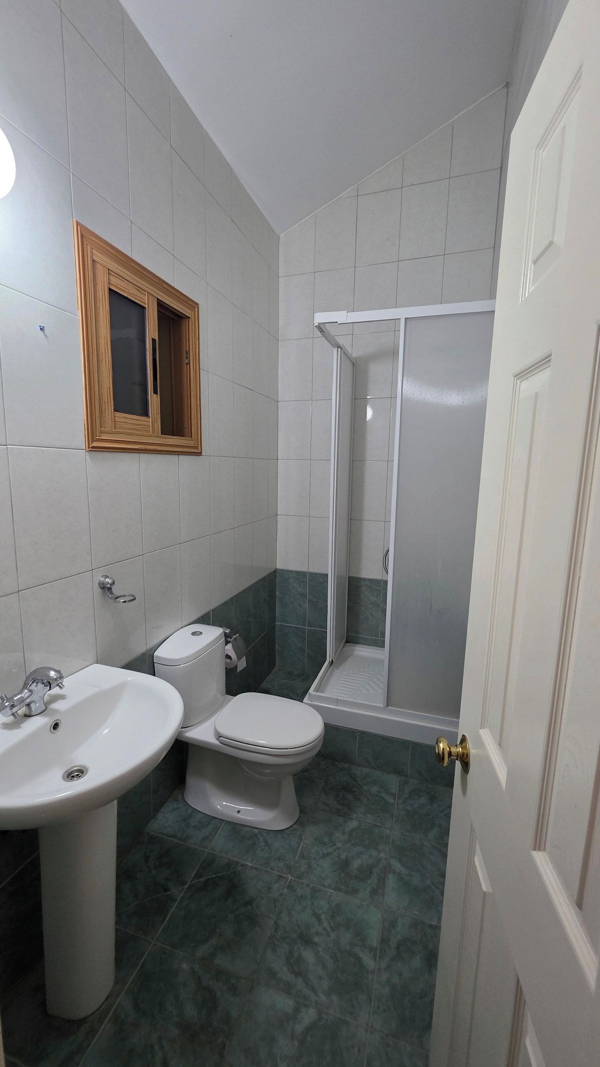 A bathroom with a sink, toilet, and shower area.