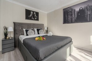 A modern bedroom with a large bed, a nightstand, a lamp, and artwork on the walls. - Lumina 3 room apart near PGE Narodowy (Warszawa)