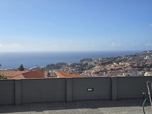 A rooftop view overlooking a coastal cityscape with buildings and the sea. - Ocean Paradise Santa Luzia (Funchal)