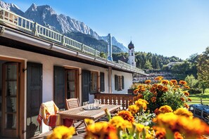 A building with a balcony overlooking a mountainous landscape. - Vacation rental with a rooftop terrace and mountain views. Perfect for the Zugspitze and Eibsee. (Grainau)