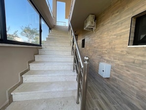 A staircase with a metal handrail leading to a landing. - Room-sea Pearl Studios Golem - First-flo (Golem)