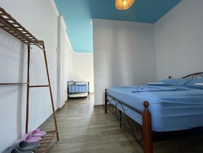 Een slaapkamer met een bed, een houten ladder en een metalen stoel.