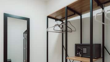 A modern room with a wooden shelving unit, a mirror, and a small white vase.