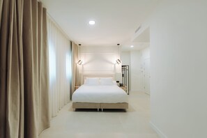 A modern hotel room with a large bed, a bedside table, a wardrobe, and a bathroom visible in the background. - Hotel Crisal (Alicante)